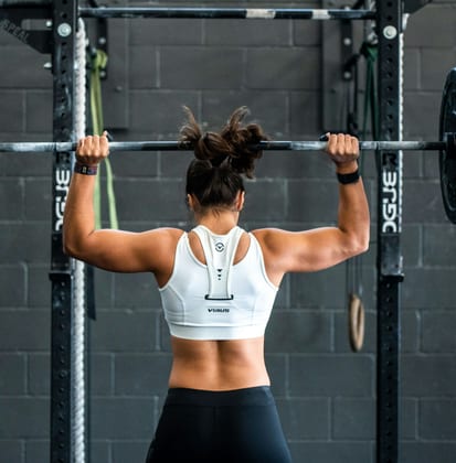 Client performing barbell squat in gym